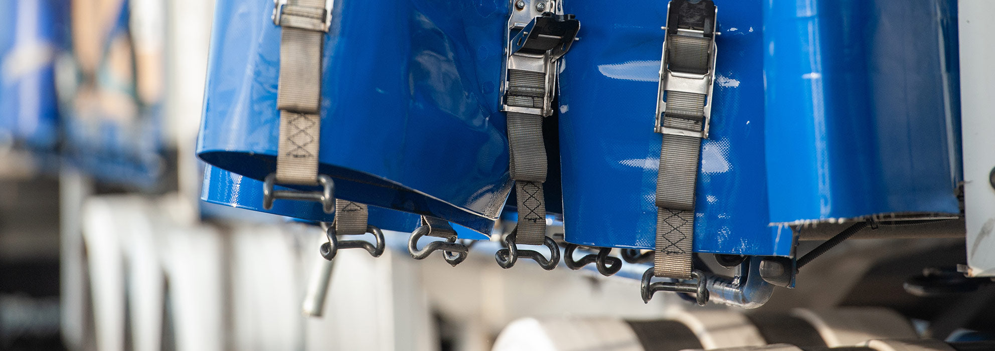Close up of blue truck bed canvas and black straps.
